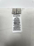 White T-shirt care and size label showing XS TP and fabric composition