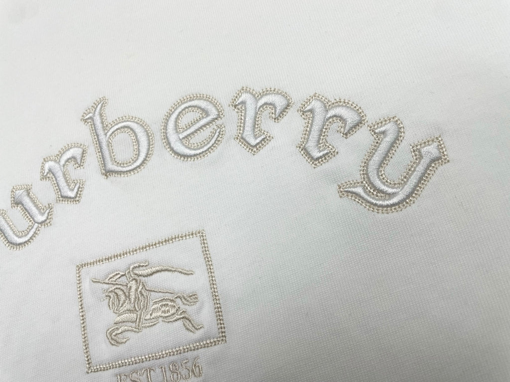 White T-shirt close-up with jeweled-style Burberry wordmark and crest