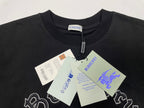 Black T-shirt with Burberry neck tag and embroidered crest logo; price tags attached.