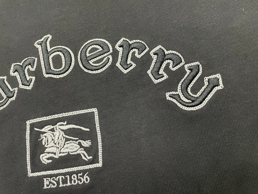 Embroidered Burberry lettering and horse crest with EST1856 on black T-shirt.