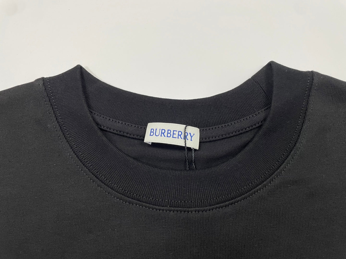 Black crewneck T-shirt neckline with Burberry size tag.