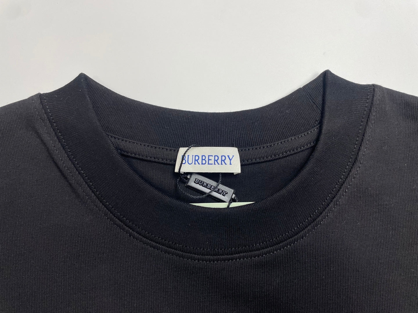 Navy crewneck T-shirt collar with Burberry brand tag at neckline