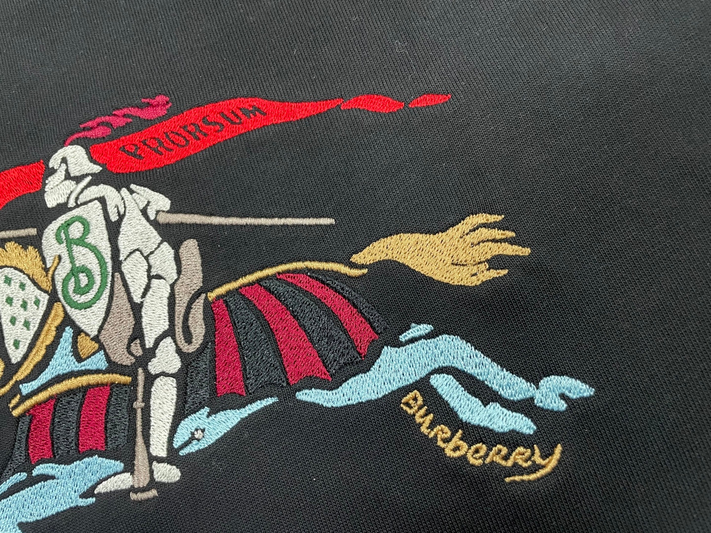 Black Burberry T-shirt close-up of mounted rider graphic and blue text