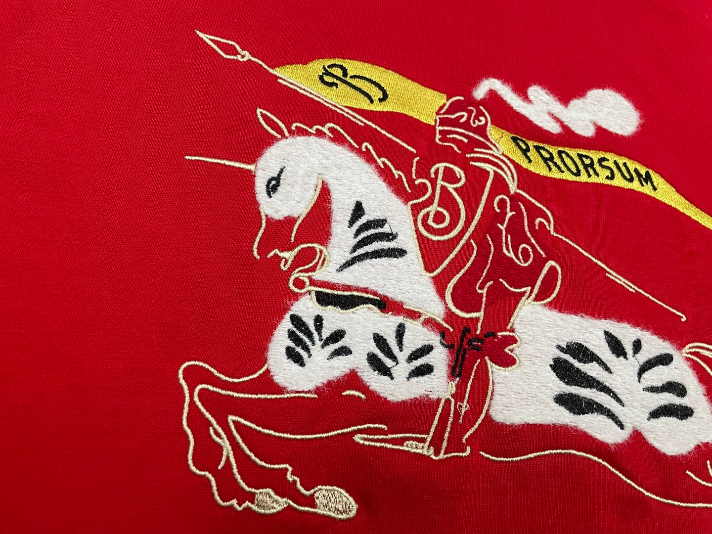 Red T-shirt fabric close-up of white and black horse illustration