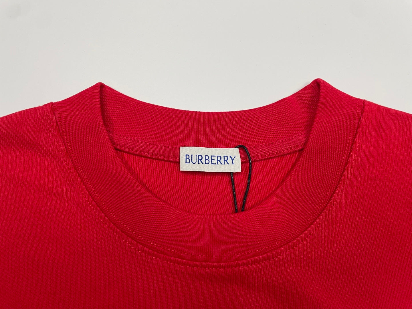 Red T-shirt neckline with white inner label and Burberry tag