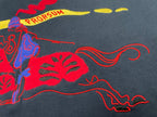 Navy T-shirt close-up with red graphic and yellow PRORSUM text, blue details.