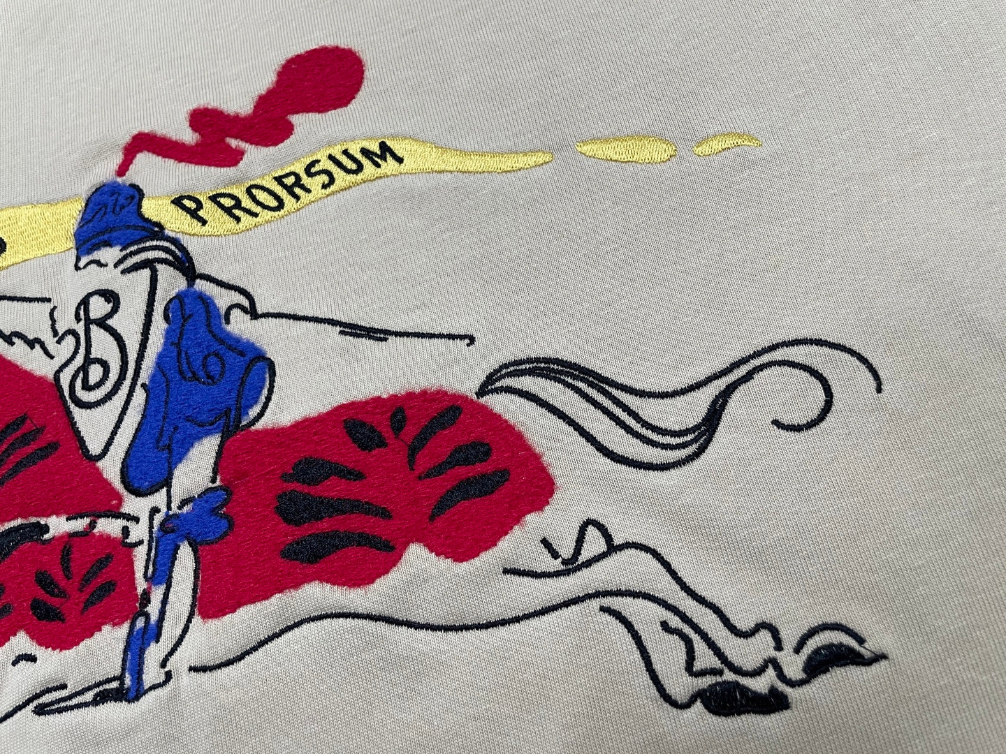Burberry beige T-shirt close-up with rider graphic and curved lines