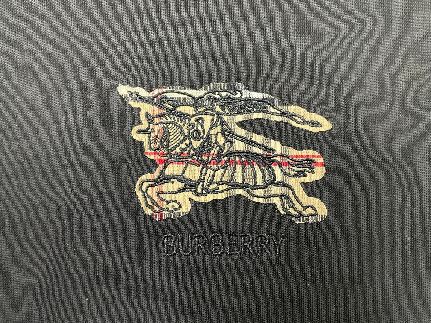 Embroidered horse logo and BURBERRY text on dark t-shirt fabric