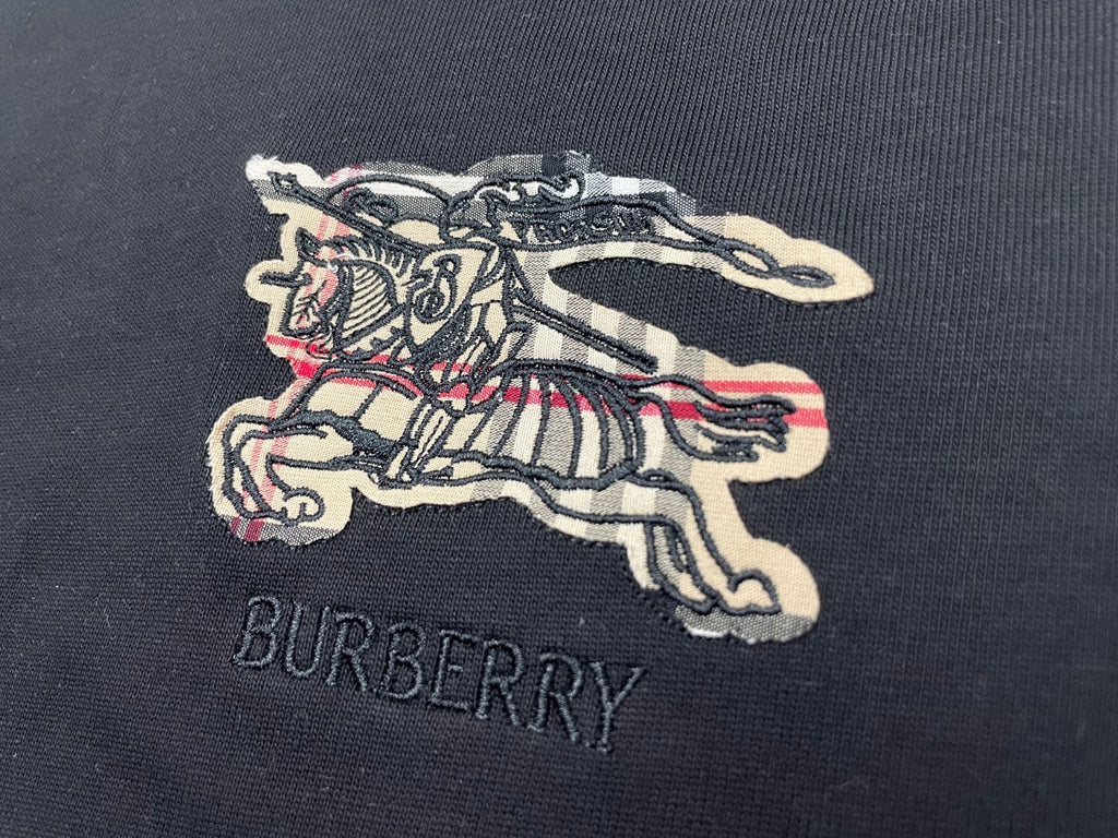 Close-up embroidered horse logo and BURBERRY text on dark t-shirt