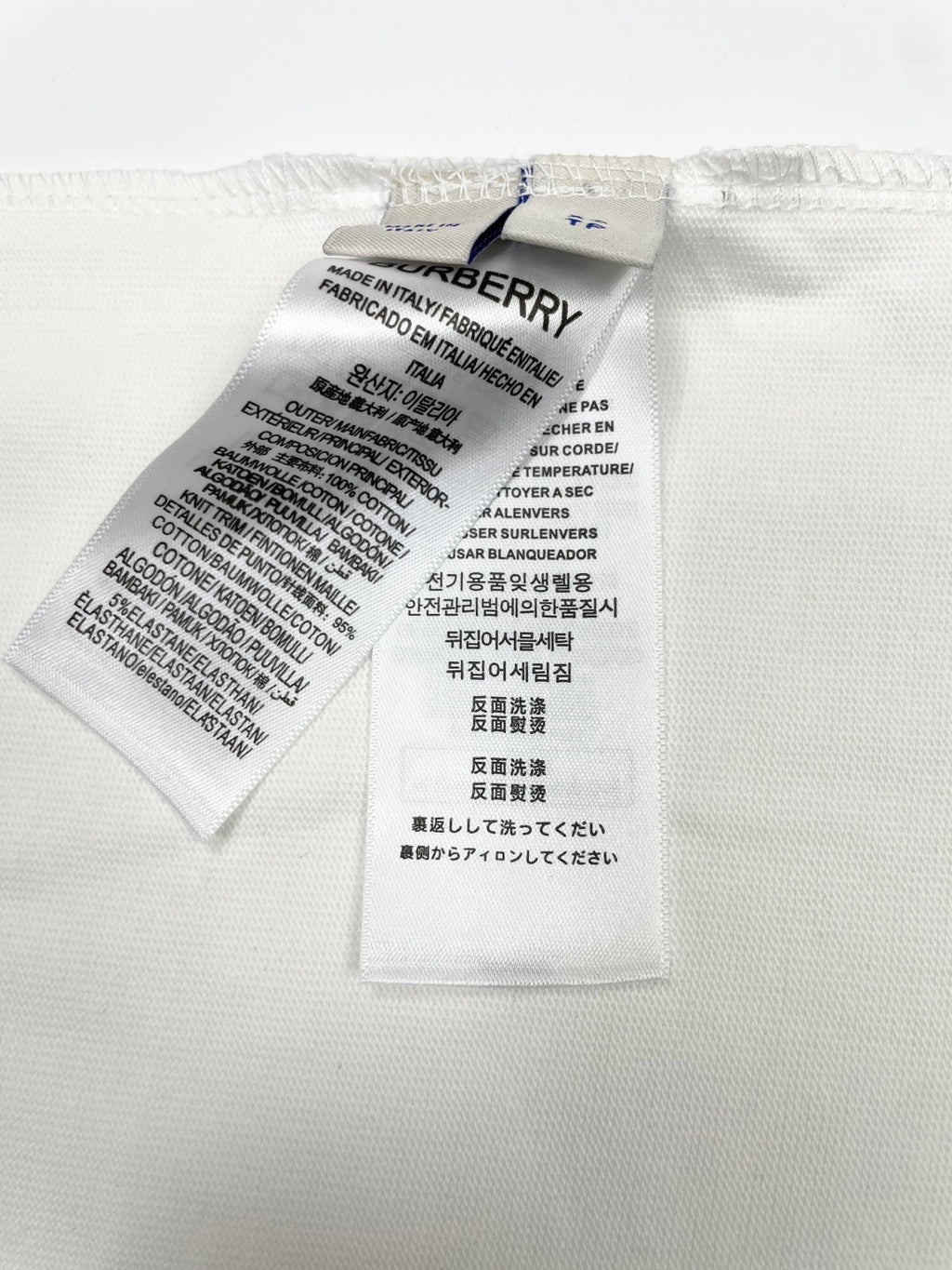 White T-shirt interior care label with washing and material instructions