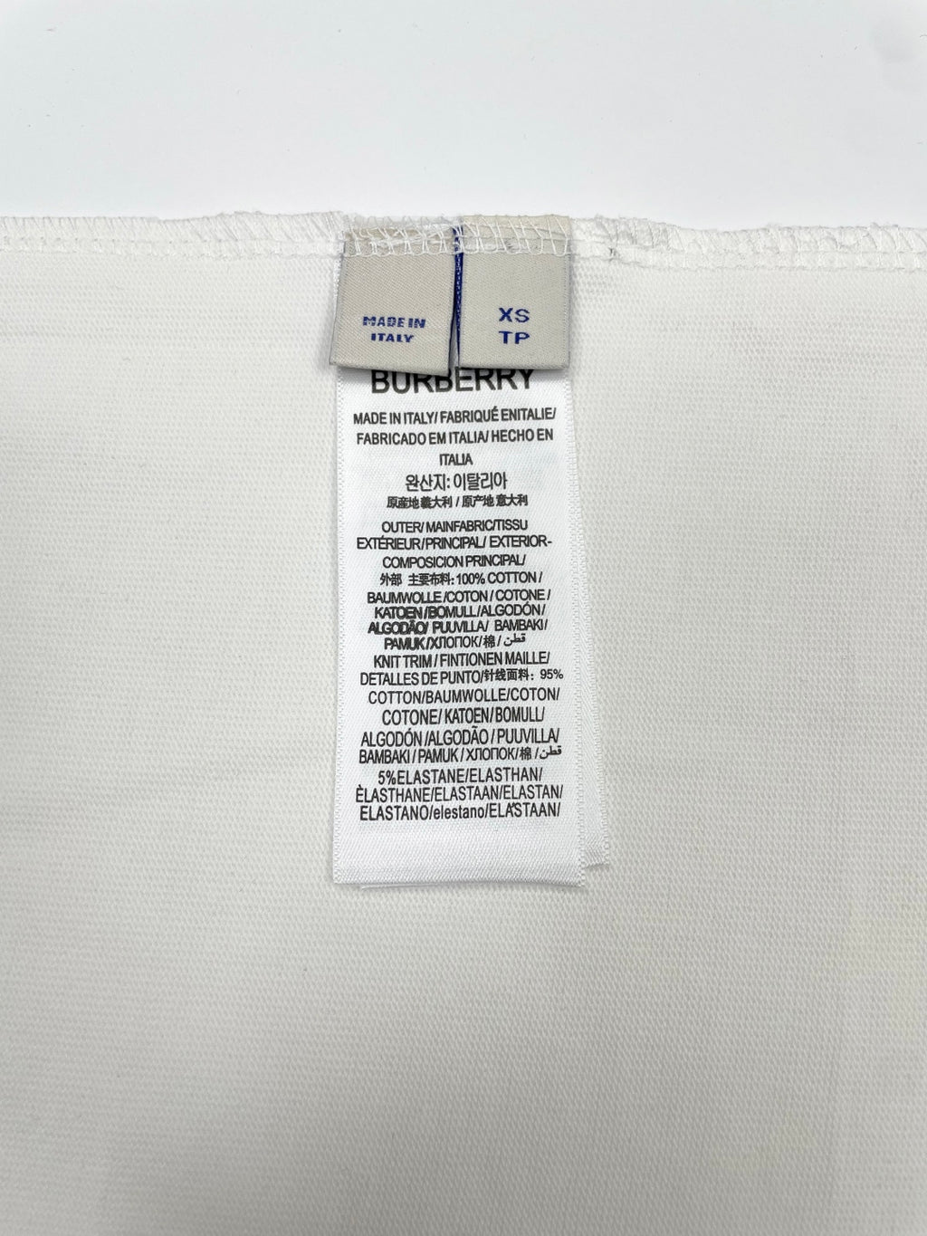 White T-shirt interior size and fabric label showing XS and Burberry