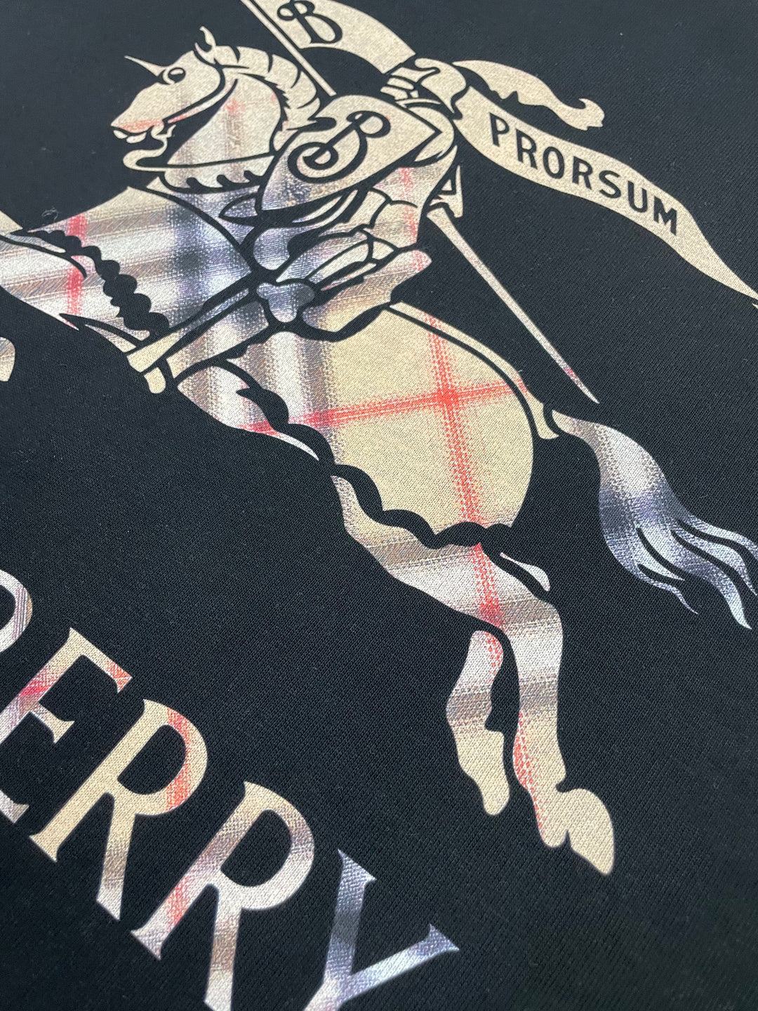 Black T-shirt close-up of horse-and-rider graphic with partial Burberry text