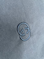 Close-up of embroidered logo on navy T-shirt fabric