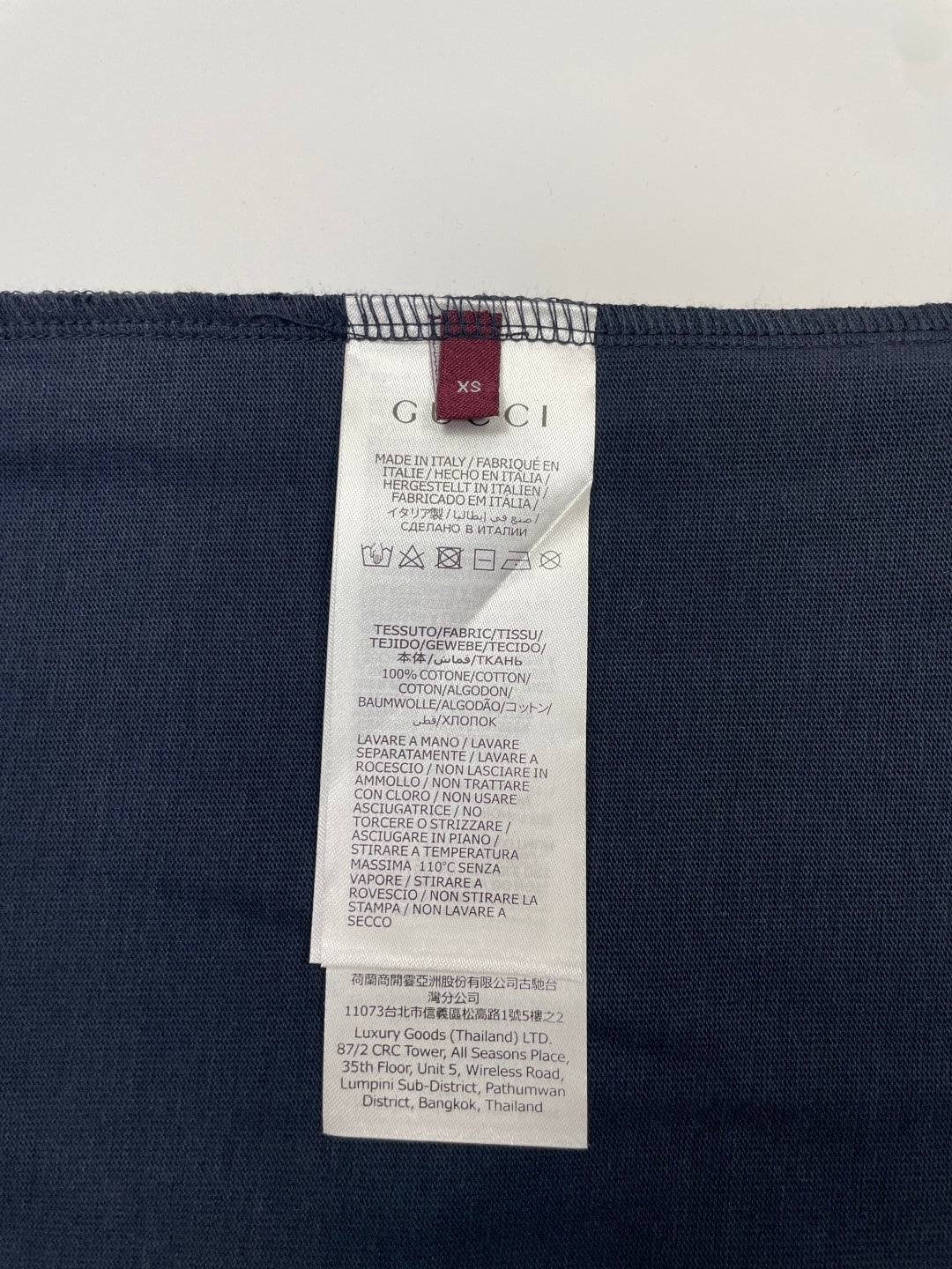 Inside view of navy T-shirt with size and care label on collar