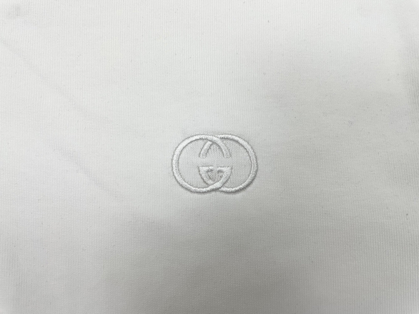 Gucci-style logo embroidery on white T-shirt fabric