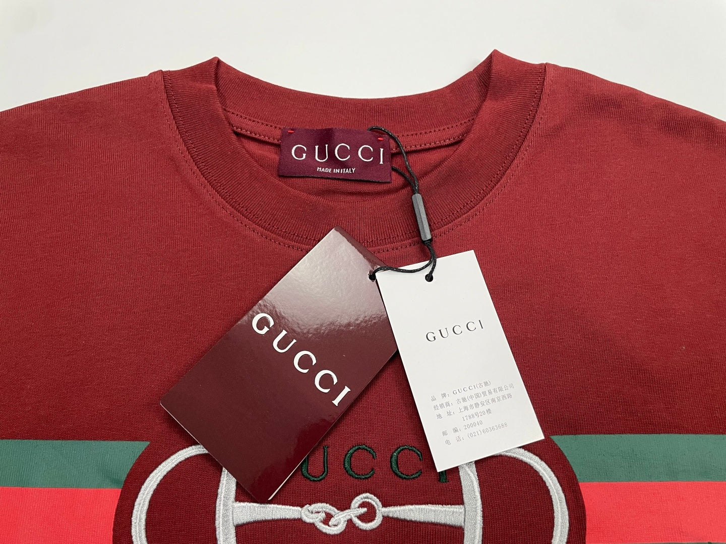 Red crewneck T-shirt with hanging tags and Gucci horsebit logo stripe