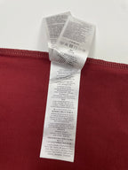 Red T-shirt with stacked white care label tags on the back hem