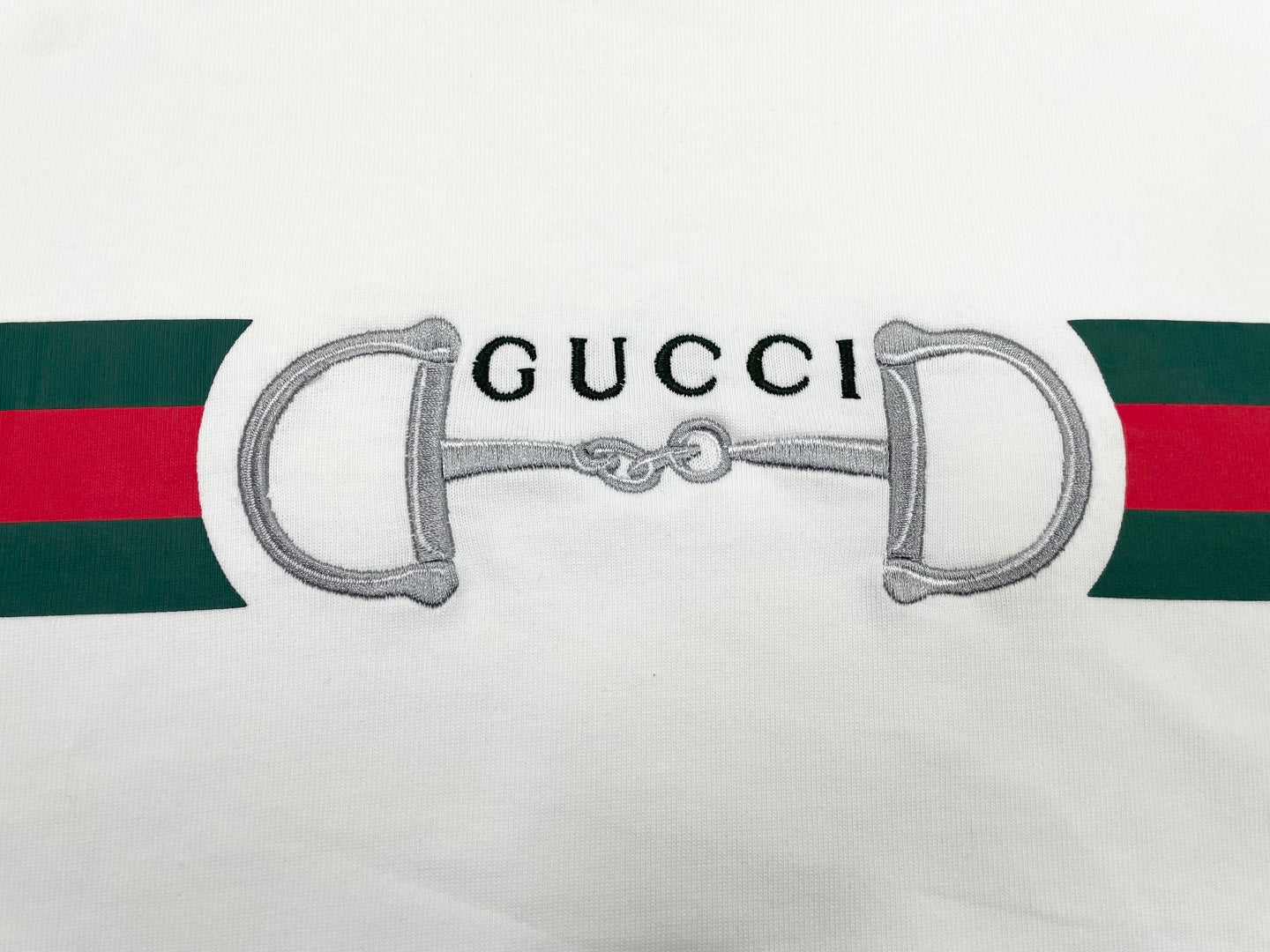 White T-shirt sleeve with green and red stripe and horsebit graphic