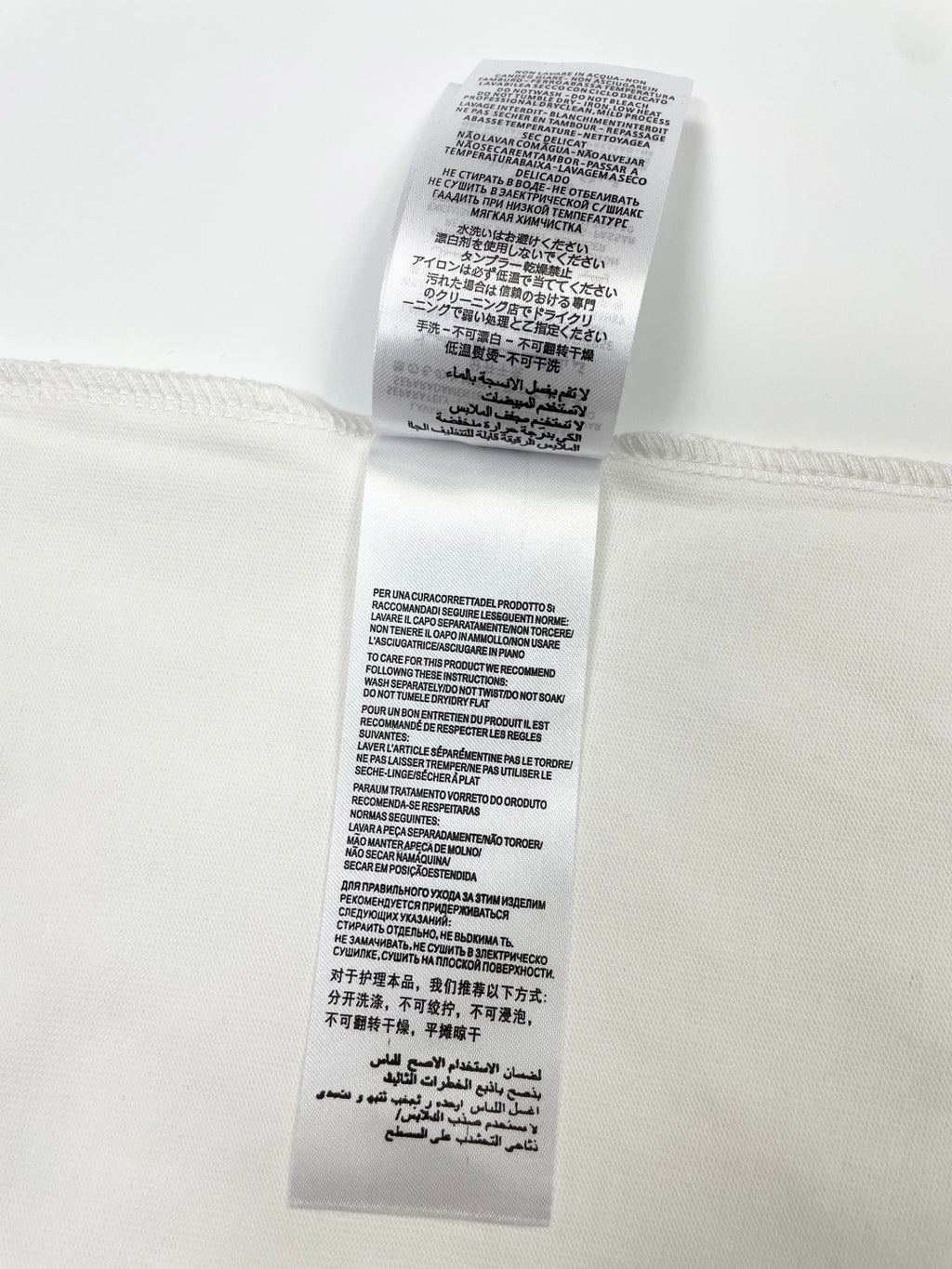 White T-shirt care label with printed instructions