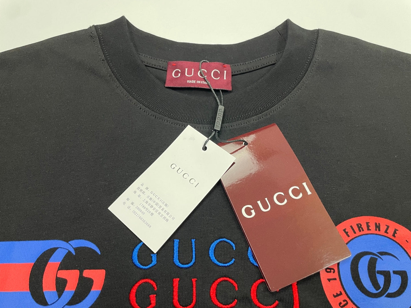Dark Gucci T-shirt neckline with GUCCI size tag and paper labels