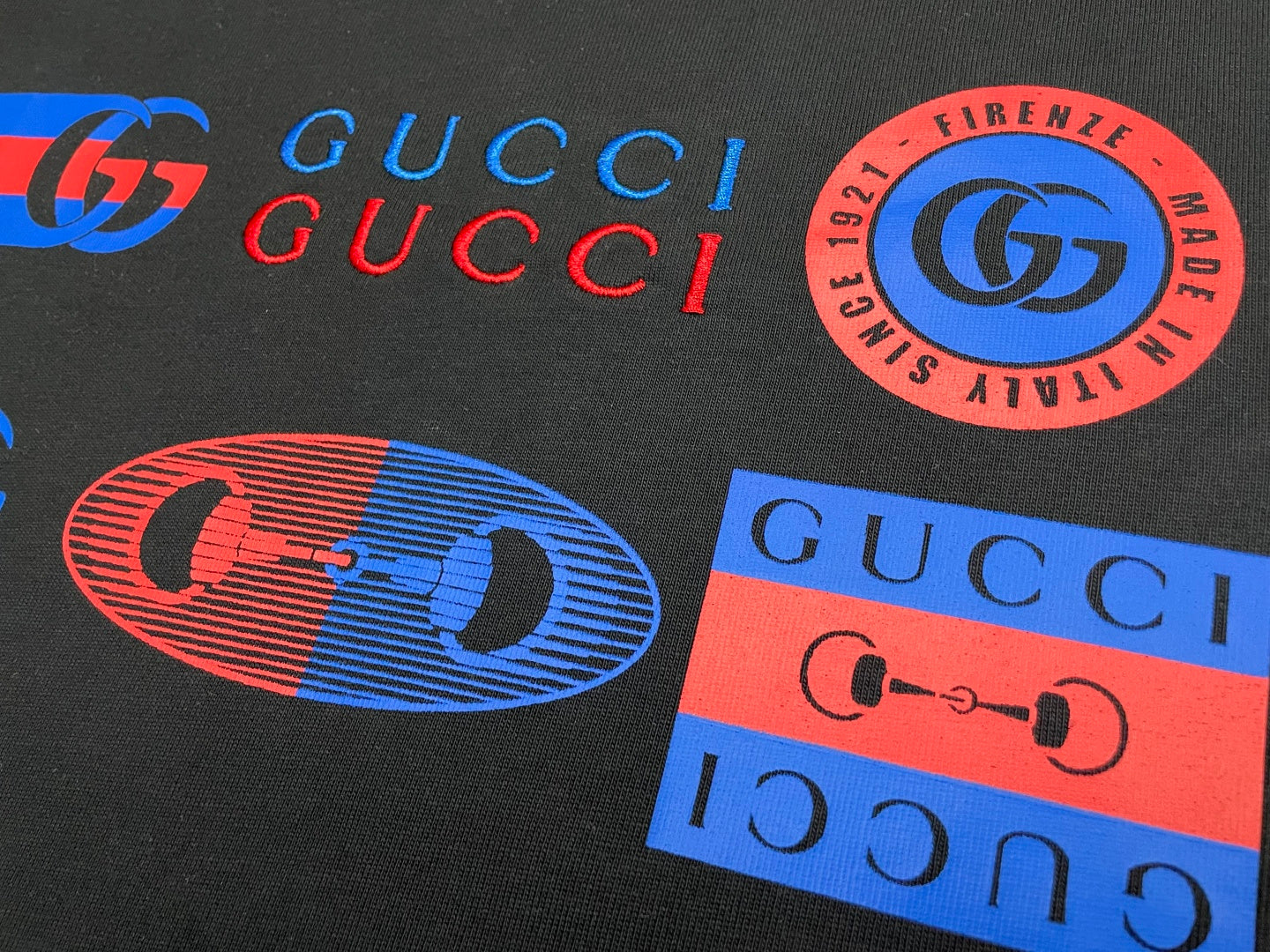 Dark Gucci T-shirt graphic logos, GUCCI text, and stamp patch