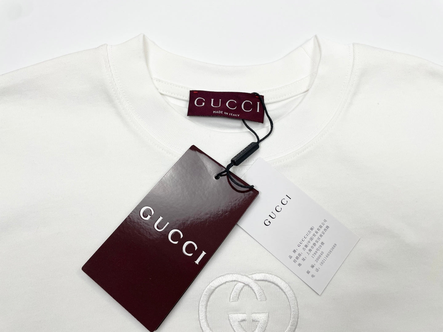 White short-sleeve T-shirt with Gucci hang tag and circular GG logo