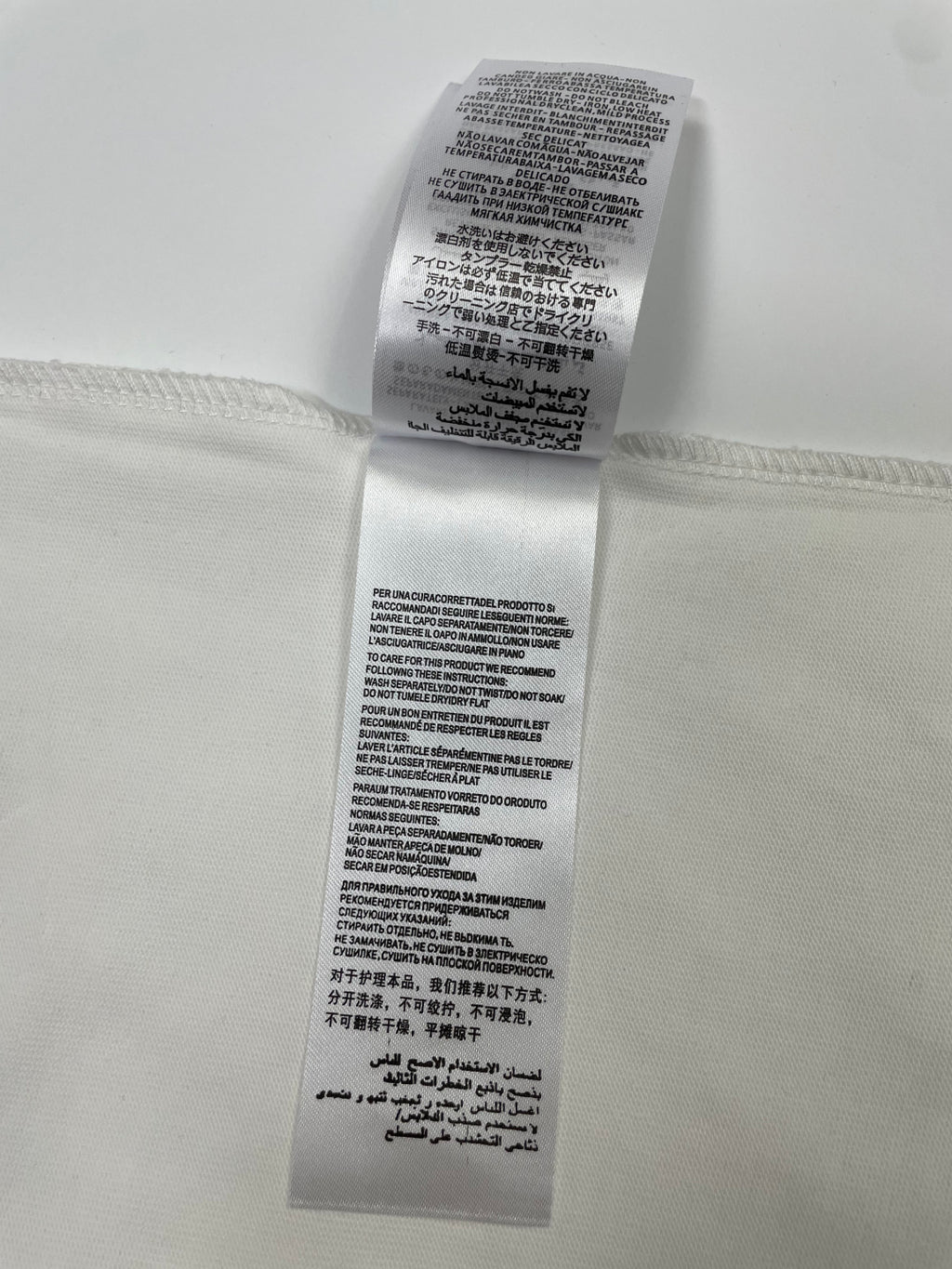 White T-shirt care label with printed washing and fabric instructions