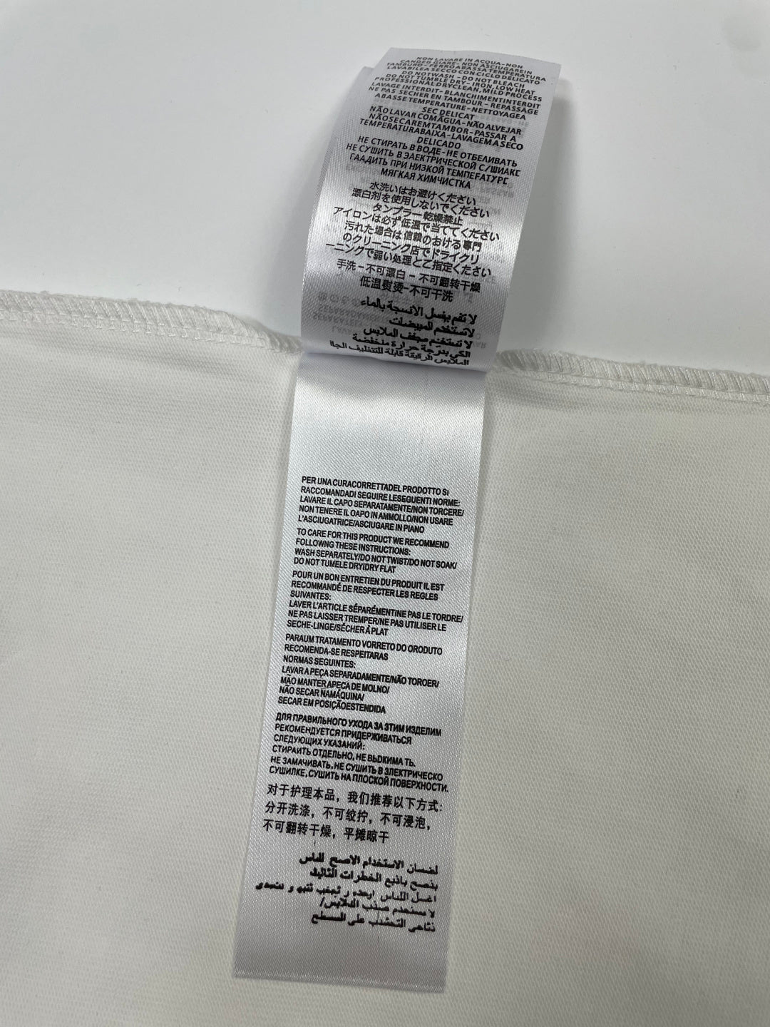 White T-shirt care label with printed washing and fabric instructions