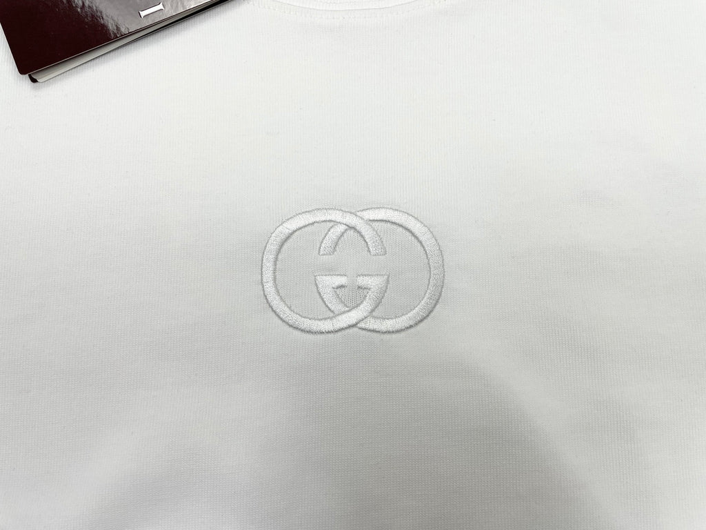White short-sleeve T-shirt with metallic GG logo emblem at center