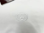White short-sleeve T-shirt with metallic GG logo emblem at center