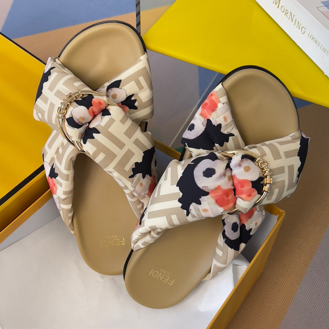Fendi slide sandals pair with FF straps and floral bow; gold buckle over tan footbeds