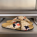 Fendi slide sandals with FF straps, floral bow, and gold-tone buckle on tan footbeds