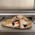 Fendi slide sandals with FF straps, floral bow, and gold-tone buckle on tan footbeds