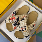 Fendi slide sandals with FF straps, floral bow, gold buckle hardware, and tan footbeds