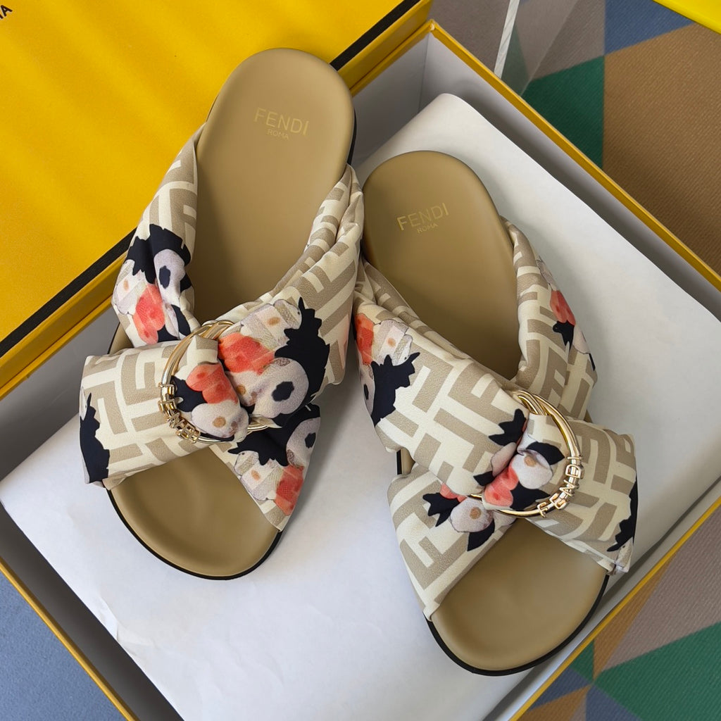 Fendi slide sandals in box: FF-pattern straps with floral bow and gold-tone buckle; tan