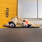 Fendi slide sandal with FF-pattern strap, floral bow, and gold-tone buckle; tan footbed