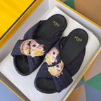 Dark navy Fendi slide sandals with floral knot straps and gold buckle hardware