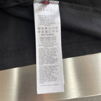 Black Gucci T-shirt care label tag with printed size and washing instructions