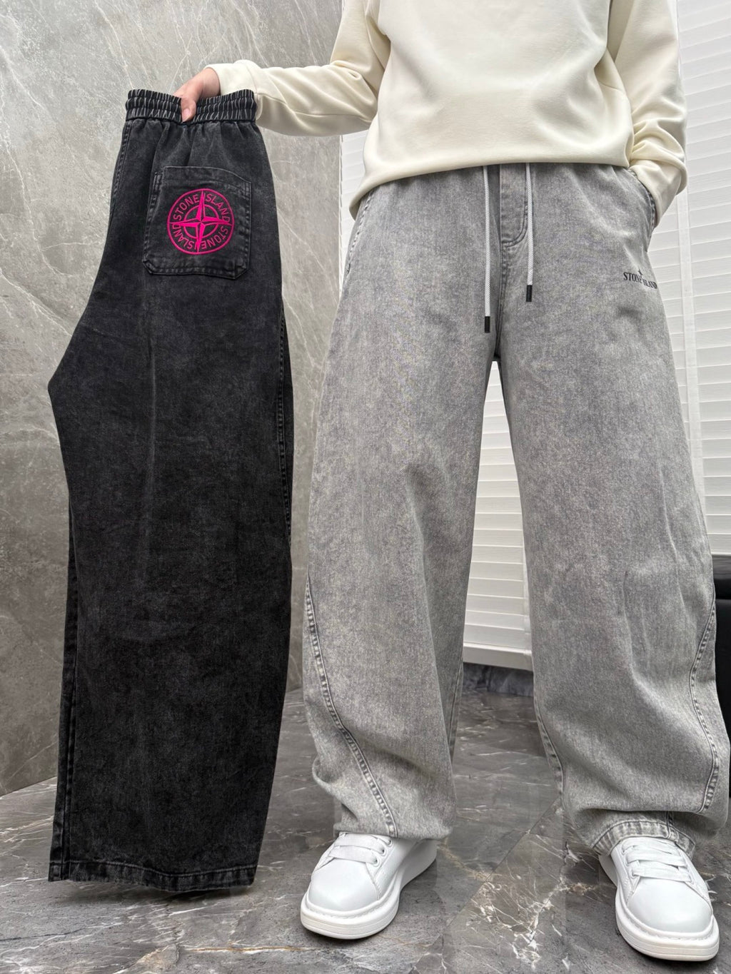 Black denim jogger pants with red logo patch and drawstring waistband