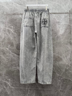 Grey denim jogger pants with stitched pockets and logo patch on right side