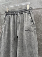 Grey stone-wash denim jogger pants with elastic waist, drawstring, and front pockets