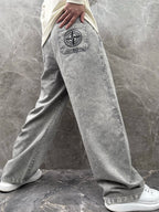 Grey stone-wash jeans-style jogger pants with logo patch and drawstring waistband