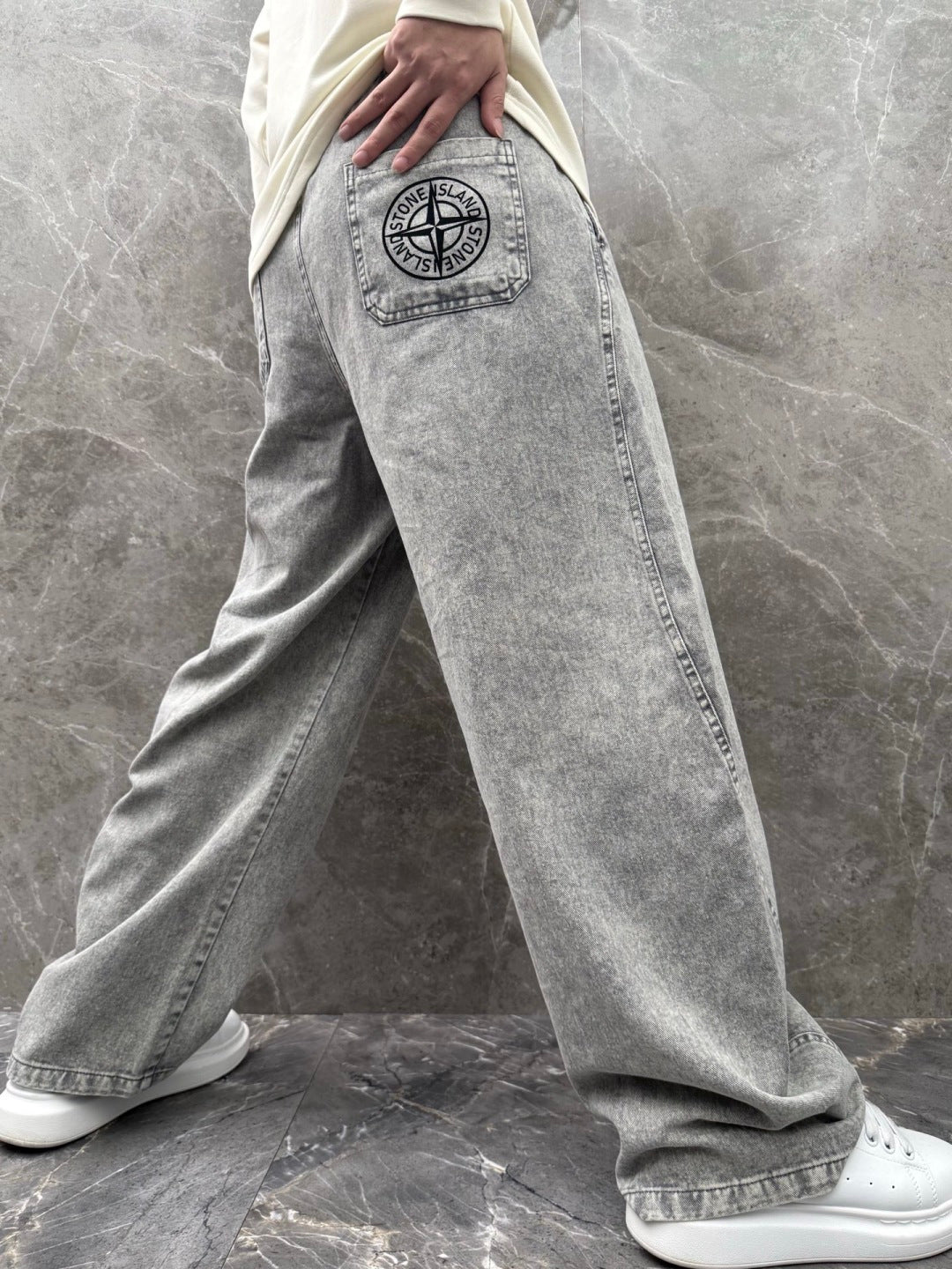 Grey stone-wash jeans-style jogger pants with logo patch and drawstring waistband