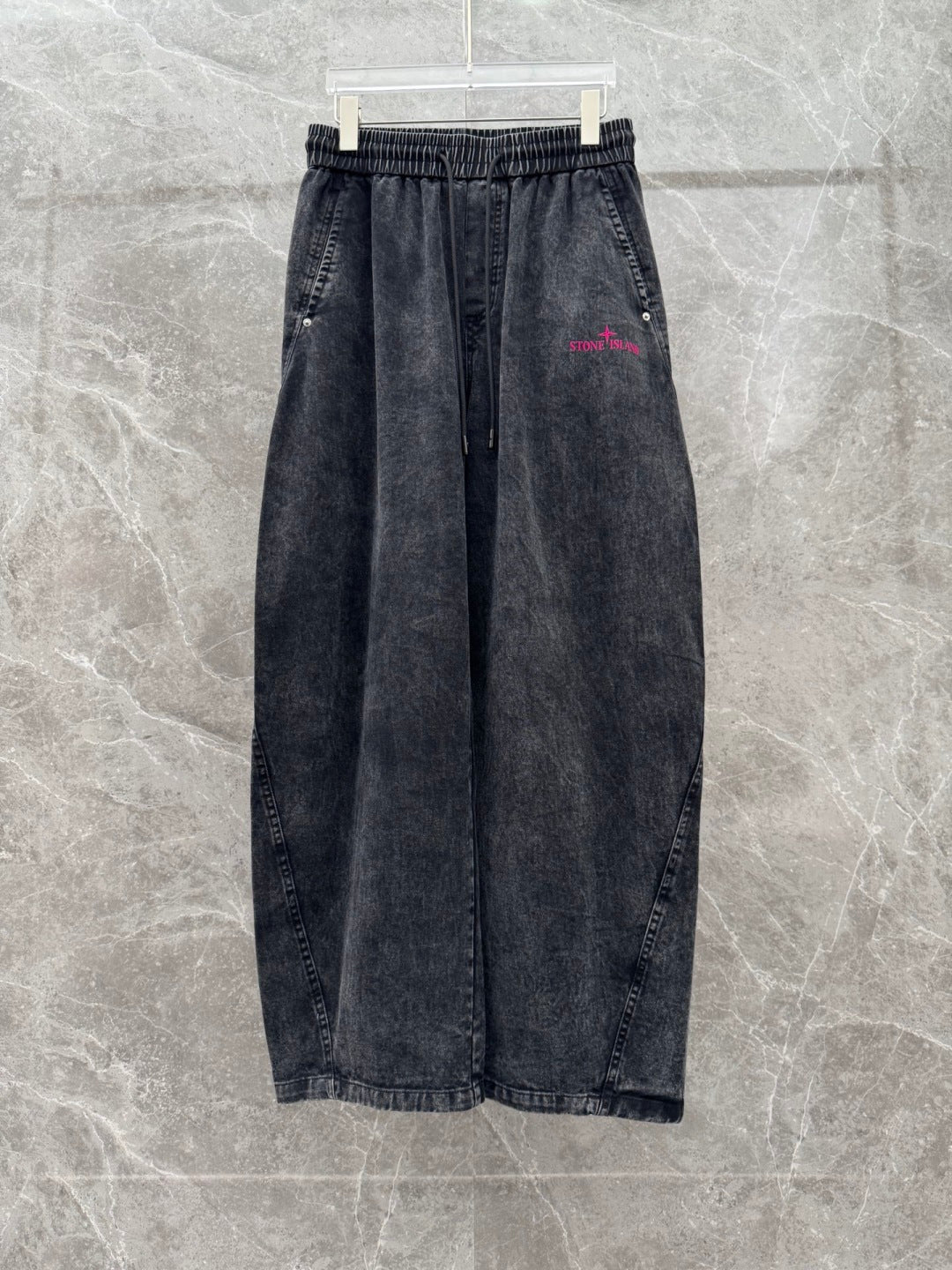 Wide-leg denim pants, dark wash, elastic waistband with drawstring; minimal front logo.