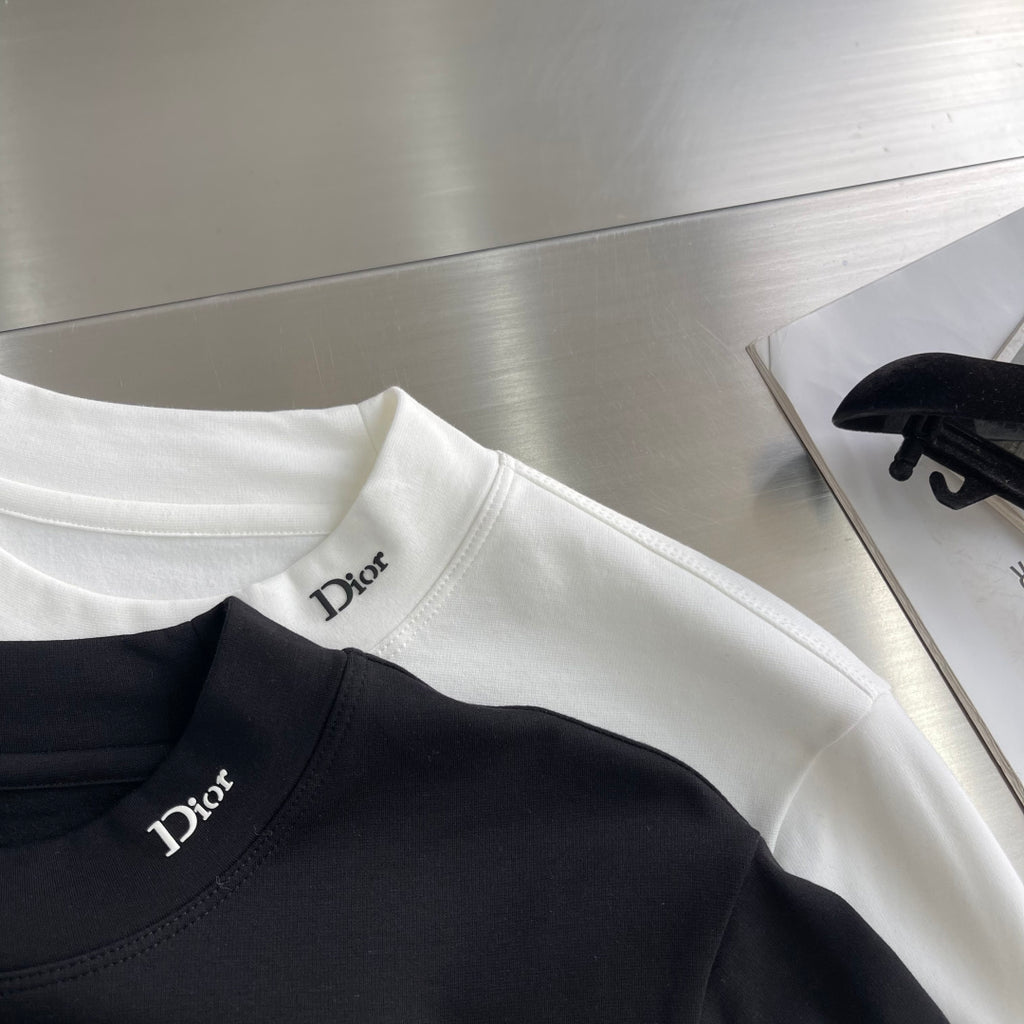 Black Dior crew-neck long-sleeve shirt with Dior logo, with a white shirt nearby