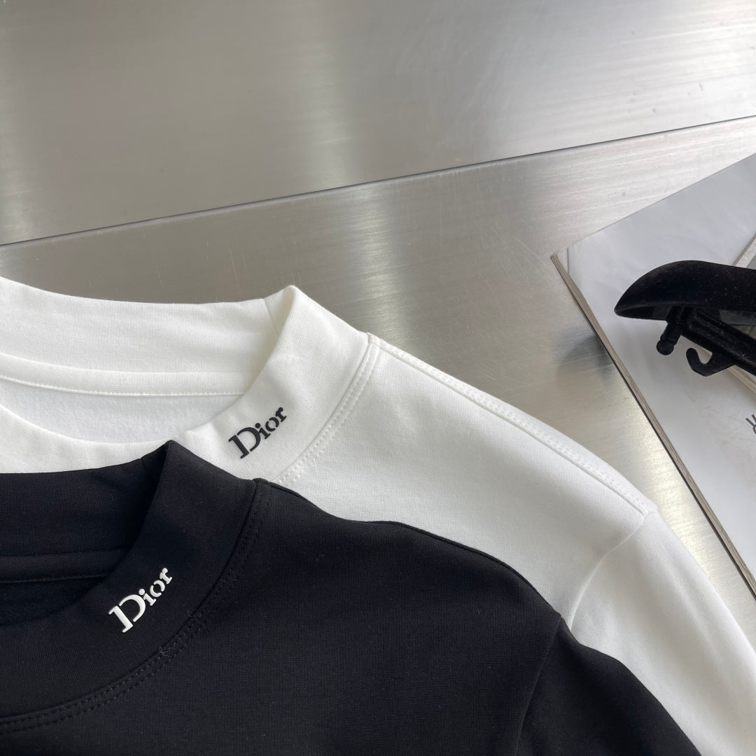 Black Dior crew-neck long-sleeve shirt with Dior logo, with a white shirt nearby