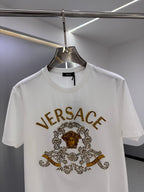 White crew-neck T-shirt with gold VERSACE logo and ornate central graphic