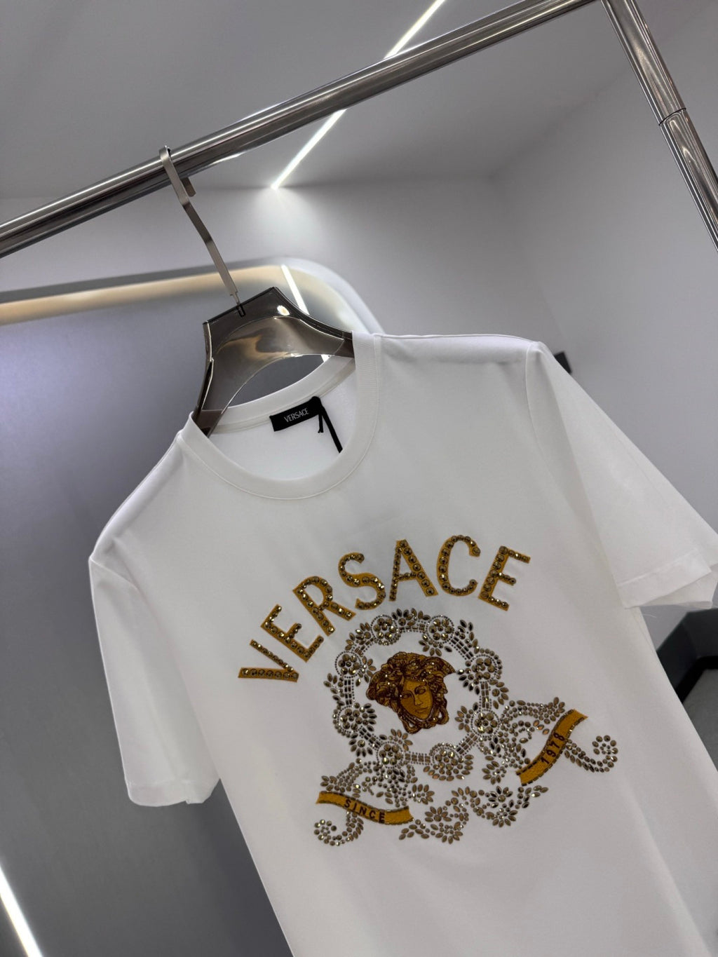 White crew-neck T-shirt with gold VERSACE logo and lion medallion graphic