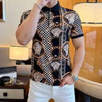 Black polo shirt with pointed collar, button placket, Medusa portrait print, and gold chain links.