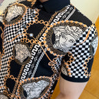 Black polo shirt with large Medusa medallion, checkered stripe, and gold chain trim on chest.
